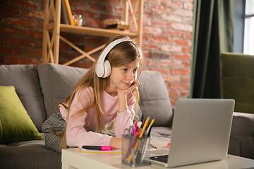 Image showing Little girl studying by group video call, use video conference with teacher, listening to online course