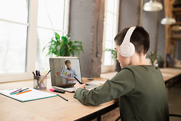 Image showing Little boy studying by group video call, use video conference with teacher, listening to online course