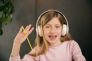 Image showing Little girl wearing headphones during online education course, lesson, view of screen