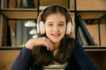 Image showing Little girl wearing headphones during online education course, lesson, view of screen