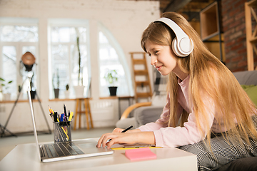 Image showing Little girl studying by group video call, use video conference with teacher, listening to online course