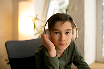 Image showing Little boy wearing headphones during online education course, lesson, view of screen