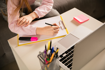 Image showing Close up hands of girl writing during group video call, use video conference with teacher, listening to online course