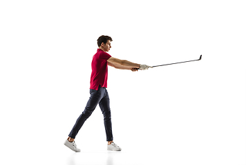 Image showing Golf player in a red shirt taking a swing isolated on white studio background