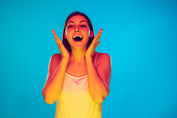 Image showing Caucasian young woman\'s portrait isolated on blue background in neon light