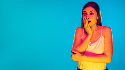 Image showing Caucasian young woman\'s portrait isolated on blue background in neon light