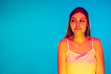 Image showing Caucasian young woman\'s portrait isolated on blue background in neon light