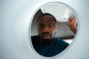 Image showing African-american man looking for job in unusual places at his home