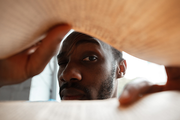 Image showing African-american man looking for job in unusual places at his home