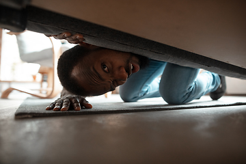 Image showing African-american man looking for job in unusual places at his home