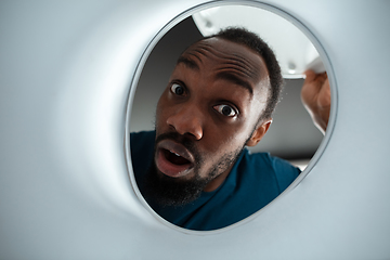 Image showing African-american man looking for job in unusual places at his home