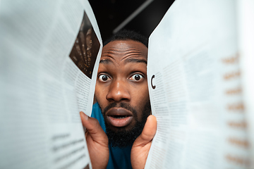 Image showing African-american man looking for job in unusual places at his home