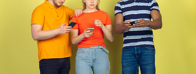 Image showing Group of friends using mobile smartphones. Teenagers addiction to new technology trends. Close up.