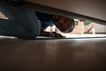 Image showing African-american man looking for job in unusual places at his home