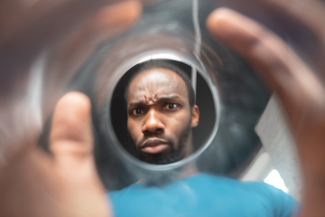 Image showing African-american man looking for job in unusual places at his home