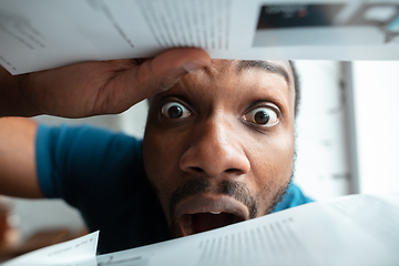 Image showing African-american man looking for job in unusual places at his home