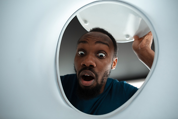 Image showing African-american man looking for job in unusual places at his home