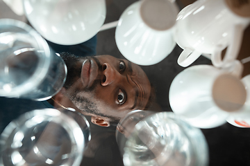 Image showing African-american man looking for job in unusual places at his home