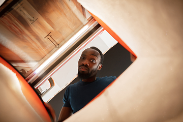 Image showing African-american man looking for job in unusual places at his home