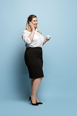 Image showing Young caucasian woman in office attire on blue background. Bodypositive female character. plus size businesswoman