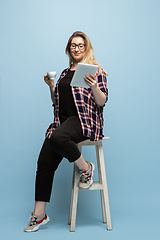 Image showing Young caucasian woman in casual wear on blue background. Bodypositive female character, plus size businesswoman