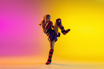 Image showing Little caucasian female kick boxer training on gradient background in neon light, active and expressive