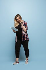 Image showing Young caucasian woman in casual wear on blue background. Bodypositive female character, plus size businesswoman