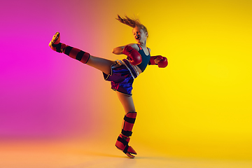 Image showing Little caucasian female kick boxer training on gradient background in neon light, active and expressive