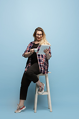 Image showing Young caucasian woman in casual wear on blue background. Bodypositive female character, plus size businesswoman