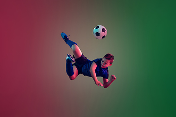 Image showing Teen male football or soccer player, boy on gradient background in neon light - motion, action, activity concept