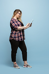 Image showing Young caucasian woman in casual wear on blue background. Bodypositive female character, plus size businesswoman