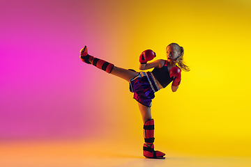 Image showing Little caucasian female kick boxer training on gradient background in neon light, active and expressive