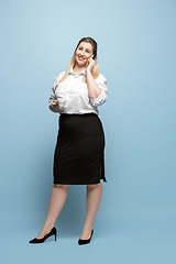 Image showing Young caucasian woman in office attire on blue background. Bodypositive female character. plus size businesswoman