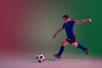 Image showing Teen male football or soccer player, boy on gradient background in neon light - motion, action, activity concept