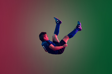 Image showing Teen male football or soccer player, boy on gradient background in neon light - motion, action, activity concept