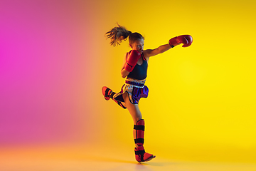 Image showing Little caucasian female kick boxer training on gradient background in neon light, active and expressive