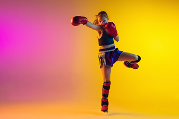 Image showing Little caucasian female kick boxer training on gradient background in neon light, active and expressive