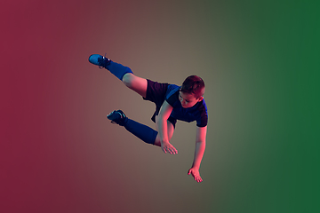 Image showing Teen male football or soccer player, boy on gradient background in neon light - motion, action, activity concept