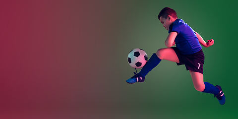 Image showing Teen male football or soccer player, boy on gradient background in neon light - motion, action, activity concept