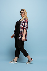 Image showing Young caucasian woman in casual wear on blue background. Bodypositive female character, plus size businesswoman