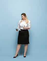 Image showing Young caucasian woman in office attire on blue background. Bodypositive female character. plus size businesswoman