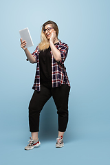 Image showing Young caucasian woman in casual wear on blue background. Bodypositive female character, plus size businesswoman