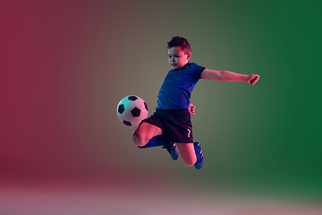 Image showing Teen male football or soccer player, boy on gradient background in neon light - motion, action, activity concept