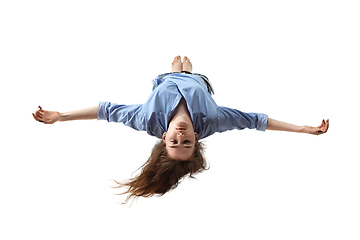 Image showing Mid-air beauty. Full length studio shot of attractive young woman hovering in air and keeping eyes closed