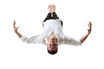 Image showing Mid-air beauty. Full length studio shot of attractive young man hovering in air and keeping eyes closed