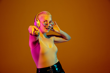 Image showing Portrait of young caucasian woman in fashionable eyewear on brown background with copyspace, unusual and freaky appearance