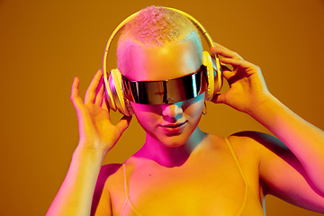 Image showing Portrait of young caucasian woman in fashionable eyewear on brown background with copyspace, unusual and freaky appearance