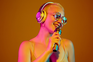 Image showing Portrait of young caucasian woman in fashionable eyewear on brown background with copyspace, unusual and freaky appearance