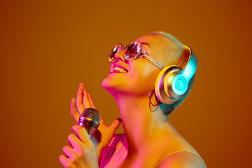 Image showing Portrait of young caucasian woman in fashionable eyewear on brown background with copyspace, unusual and freaky appearance