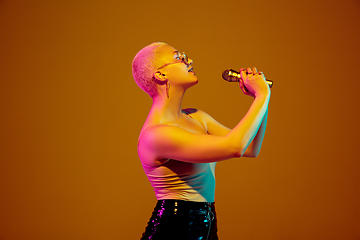 Image showing Portrait of young caucasian woman in fashionable eyewear on brown background with copyspace, unusual and freaky appearance